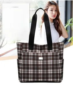 Détail du grand sac cabas à carreaux avec poche frontale et longue bandoulière en tissu