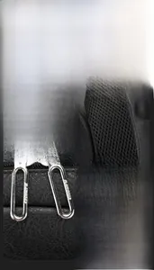 Detail of smooth metal zippers, breathable mesh straps and reinforced handle on black backpack