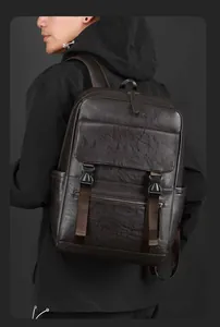 Détail du sac à dos en cuir marron foncé avec sangles à boucle et texture