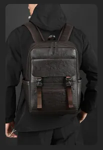 Détail du sac à dos en cuir marron foncé avec boucles et poche latérale sur un modèle