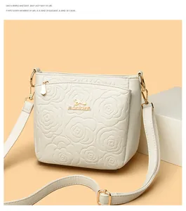 Close-up of embossed peony pattern on cream leather bucket bag with gold hardware