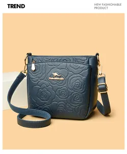 Detail of dark blue leather bucket bag with rose floral embossing and golden kangaroo logo
