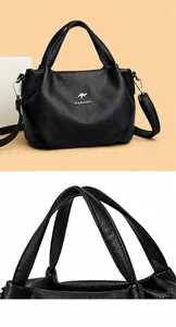 Close-up of black lychee leather handbag with kangaroo logo and comfortable handles