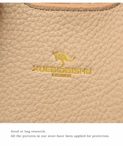 Dettaglio borsa beige in pelle martellata con logo a canguro dorato e cuciture rifinite