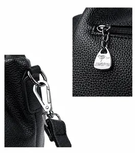 Close-up of silver metal hardware and textured litchi grain leather on black handbag