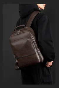 Detail view of dark brown faux leather backpack with premium litchi grain texture