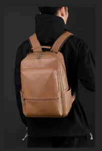 Rear view of model wearing a large brown pebbled leather business travel backpack