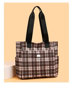 Détail du sac cabas à carreaux avec poche zippée avant et compartiments latéraux
