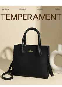 Macro detail of black lychee grain leather tote bag with gold kangaroo logo and hardware