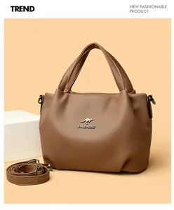 Detail of brown lychee grain leather handbag with silver kangaroo logo and adjustable strap
