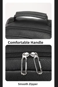 Detail of comfortable padded handle and smooth silver double zippers on black leather bag