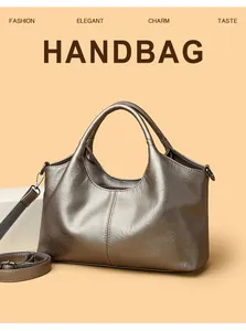 Detail of metallic bronze leather handbag featuring fine stitching and dual rolled handles
