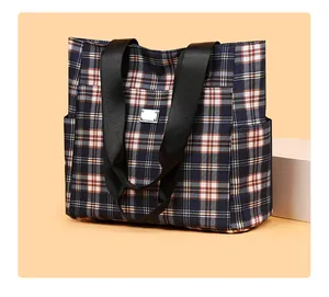 Détail du grand sac cabas à carreaux avec sangles en nylon et plaque logo argentée