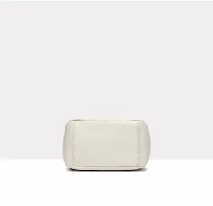 Detail view of the off-white leather bucket bag bottom with pebble grain texture