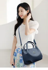 Detail of blue leather handbag with pebble texture and adjustable shoulder strap