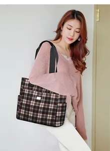Détail du grand sac cabas à carreaux montrant la bandoulière en nylon sur un modèle