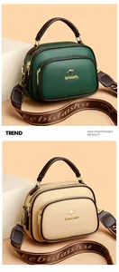 Close-up of stylish faux leather boston bags in green and beige with kangaroo logo details