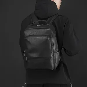 Man wearing a large capacity black leather business backpack with front zipper pockets