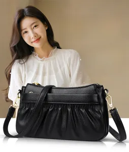 Close-up of black cowhide leather bag with unique pleated texture and gold hardware