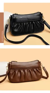 Detailed view of leather crossbody bags with pleated design and gold metal hardware