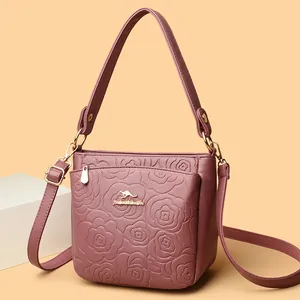 Leather bucket bag for women featuring rose embossing and adjustable shoulder strap
