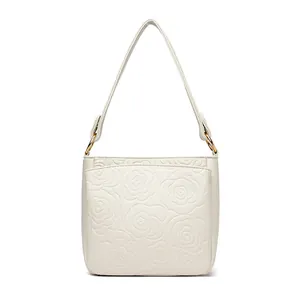 Off-white lychee leather bucket bag with embossed camellia and gold hardware