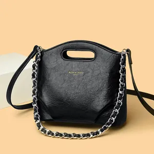 Bolso cubo chic de cuero plisado negro con letras doradas y detalle de cadena plata