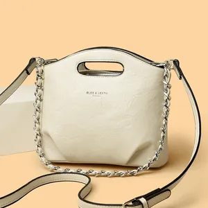 Bolso bombonera plisado de cuero crema con cadena metálica y asa para mujer