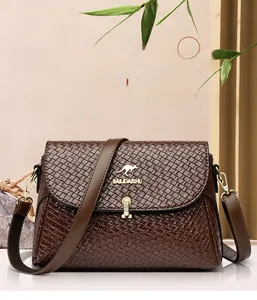 Detail of a dark brown woven leather crossbody bag with golden kangaroo emblem and lock