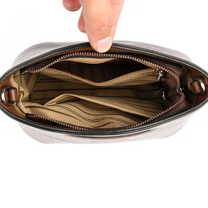 Interior del bolso saco de piel para mujer con forro de rayas y bolsillo con cremallera