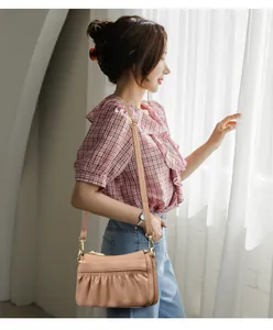 Detail of soft leather shoulder bag featuring elegant pleats and golden hardware