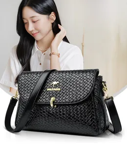 Close-up of black woven leather shoulder bag with gold kangaroo logo and buckle