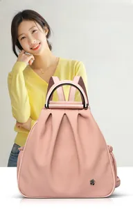 Close-up of pink leather handbag showing pleated texture and black camellia logo