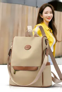 Detail of water-resistant khaki backpack with kangaroo logo and brown leather trim