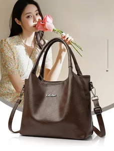 Détail du sac cabas marron foncé en cuir vintage avec logo argenté et bandoulière réglable