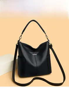Detail of black pebbled leather bucket bag with silver logo and side pocket for daily commute