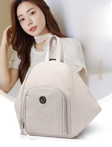 Gros plan d'un sac à dos polyvalent en toile crème avec un emblème de kangourou en métal