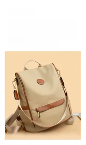 Detail of beige canvas backpack featuring a kangaroo logo patch and gold hardware