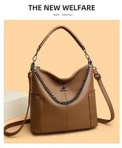 Detail of brown lychee leather bucket bag featuring kangaroo metal logo and chain strap