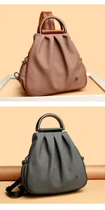 Close-up of dual-purpose leather backpacks in brown and grey with metal flower detail