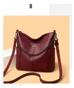 Macro detail of wine red pebbled leather bag with metal chain and kangaroo logo