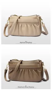 Detailed comparison of apricot and elephant gray leather crossbody bags with pleat textures