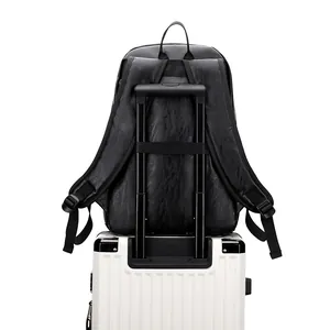 Sac à dos professionnel en cuir noir avec sangle de bagage sur une valise blanche