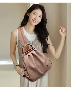 Detail view of pink fabric backpack with metal handle and pleated texture design