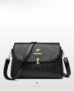 Detail of black woven leather crossbody bag with golden kangaroo logo and metal hardware
