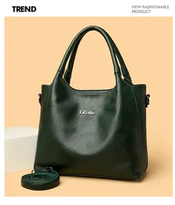Détail du sac cabas en cuir vert foncé avec logo argenté et bandoulière réglable