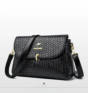 Close-up of black woven texture leather crossbody bag with golden kangaroo logo