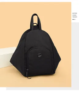 Détail d'un sac à dos géométrique noir avec poche zippée frontale et logo en métal