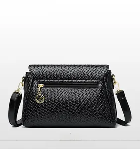 Detail view of woven leather bag back with gold logo zipper and functional pocket