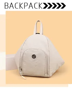 Détail frontal du sac à dos en nylon beige avec poche zippée et logo métallique